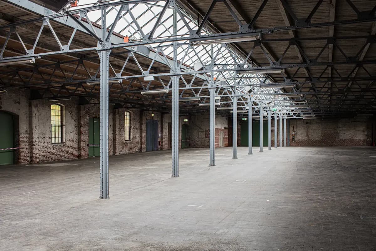 Empty industrial room with exposed columns and a concrete floor