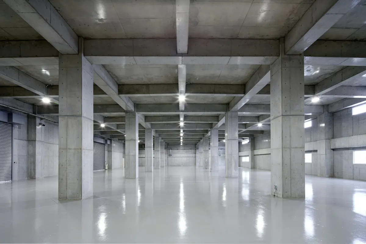 Large empty warehouse with a smooth reflective grey floor
